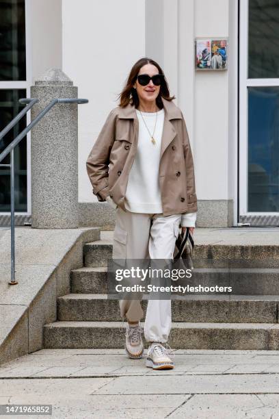 Influencer and style icon Annette Weber, wearing beige cargo pants by Second Female, a dark beige trench jacket by Max Mara, a white cashmere...