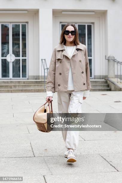 Influencer and style icon Annette Weber, wearing beige cargo pants by Second Female, a dark beige trench jacket by Max Mara, a white cashmere...