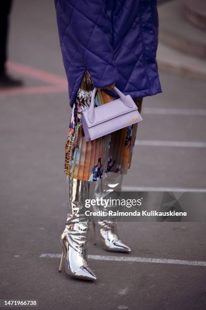 Guest is seen wearing purple jacket, Jacquemus bag, skirt with floral print, silver boots outside the The Row show during Paris Fashion Week -...