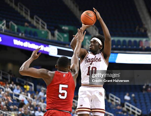 Prince Aligbe of the Boston College Eagles shoots against Brandon Huntley-Hatfield of the Louisville Cardinals during the first half of their game in...