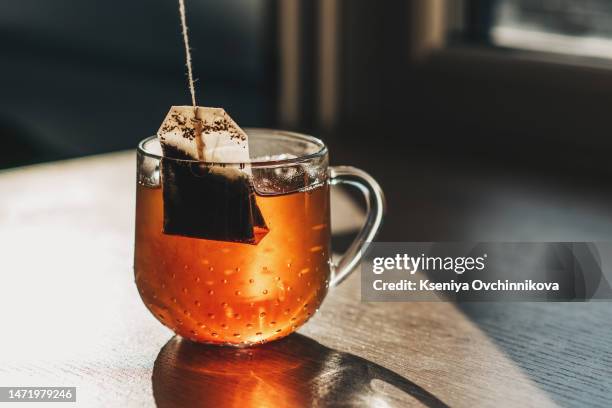 tea bag put in transparent glass teacup - tazza da tè foto e immagini stock