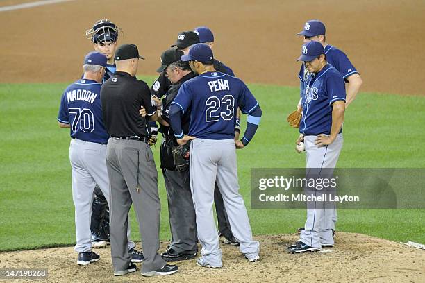 Umpire Tim Tschida checks the glove of Joel Peralta of the Tampa Bay Rays during an interleague baseball game against the Washington Nationals at...