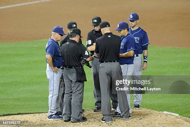Umpire Tim Tschida checks the glove of Joel Peralta of the Tampa Bay Rays during an interleague baseball game against the Washington Nationals at...