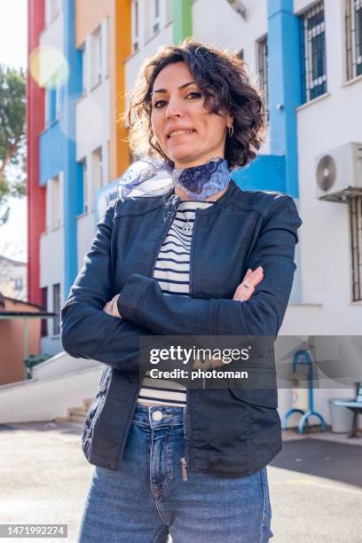 young woman standing in front of school building - mid volwassen vrouw stockfoto's en -beelden