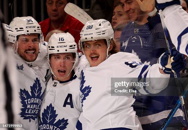 Auston Matthews of the Toronto Maple Leafs is congratulated by teammates Mitchell Marner and William Nylander after Matthews scored the game winning...
