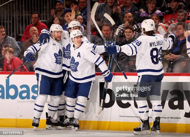 Auston Matthews of the Toronto Maple Leafs is congratulated by teammates Morgan Rielly, Mitchell Marner and William Nylander after Matthews scored...