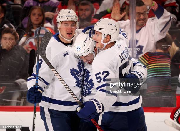 Michael Bunting of the Toronto Maple Leafs is congratulated by teammates Justin Holl and Noel Acciari after he scored during the third period against...