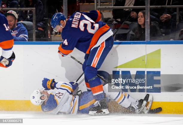 Jack Quinn of the Buffalo Sabres is checked by Scott Mayfield of the New York Islanders during the third period at the UBS Arena on March 07, 2023 in...