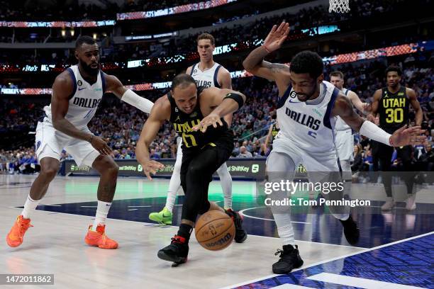 Kyrie Irving of the Dallas Mavericks and Tim Hardaway Jr. #11 of the Dallas Mavericks scramble for the ball against Talen Horton-Tucker of the Utah...