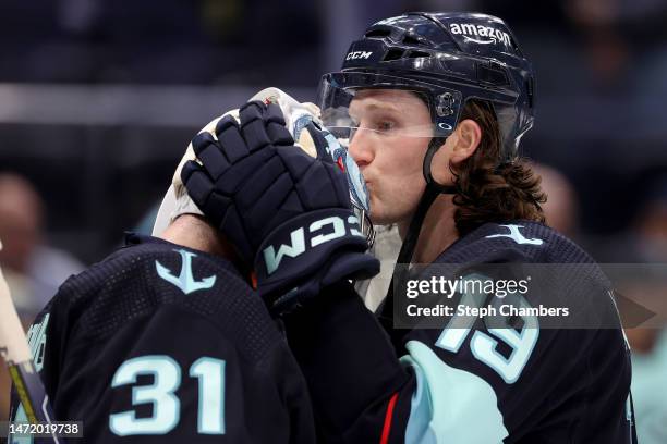 Jared McCann of the Seattle Kraken kisses the helmet of Philipp Grubauer after their 5-2 win against the Anaheim Ducks at Climate Pledge Arena on...