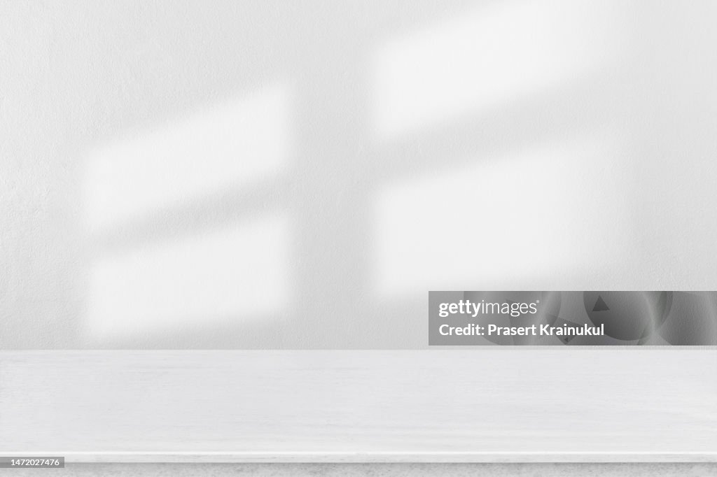 Shadow on a white concrete walls on table.