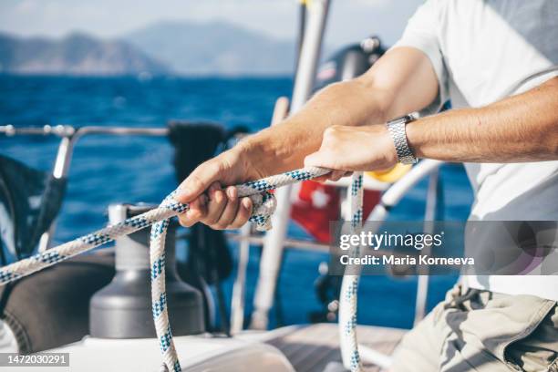 sailor operating the rope winch. - sailor arm stock pictures, royalty-free photos & images