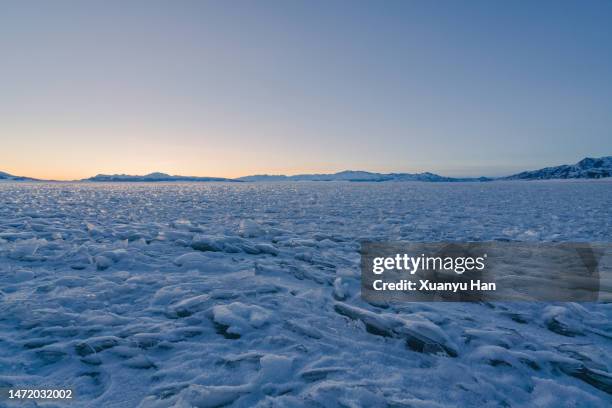 cracked ice on the surface of a lake - snowy wilderness stock pictures, royalty-free photos & images