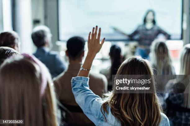 vista posteriore della donna creativa che fa una domanda sull'evento educativo in ufficio. - riunione foto e immagini stock