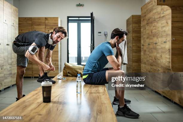 young athletic man preparing for sports training at gym's locker room. - mens changing room stock pictures, royalty-free photos & images