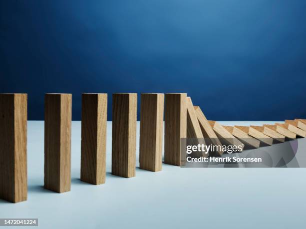 wooden blocks falling over - effet domino photos et images de collection