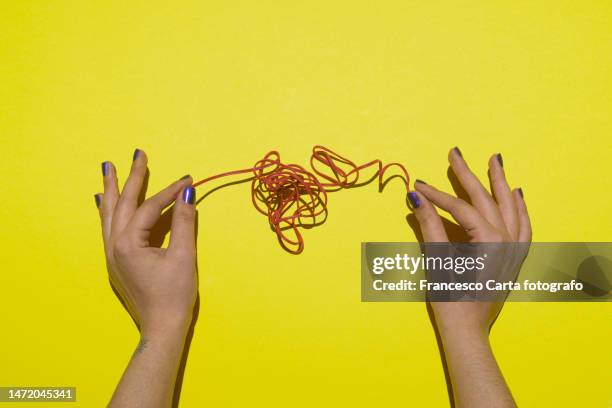 hands holding a tangled thread - bad buzz stock pictures, royalty-free photos & images