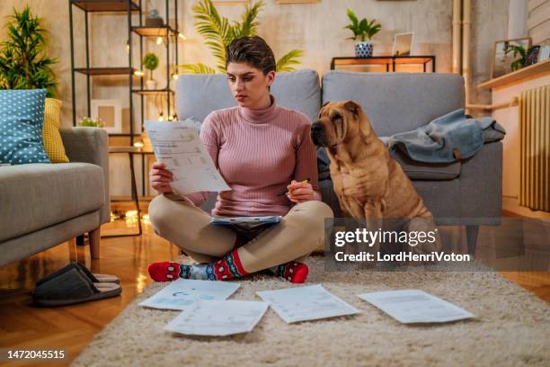 woman manages expenses and bills with a dog by her side - save a pet stock pictures, royalty-free photos & images