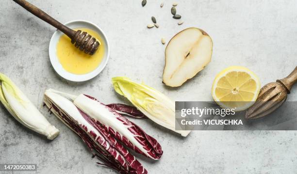 chicory salad ingredients with pear, honey and lemon on light table background - chicoree stock-fotos und bilder