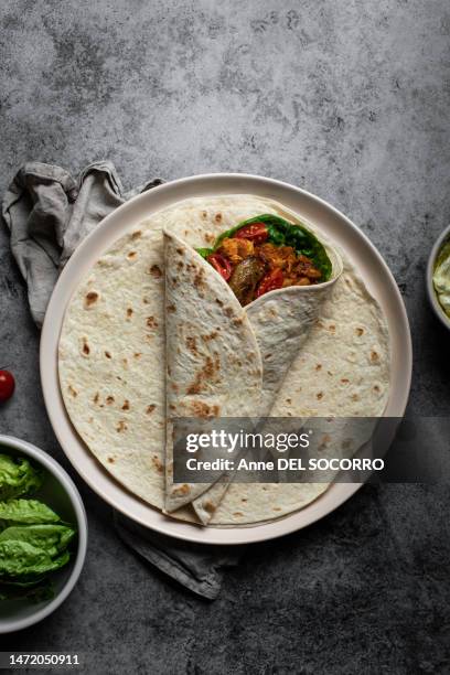 kebab wrap tortilla with tomatoes potatoes salad chicken and yogurt sauce - tortilla stock-fotos und bilder