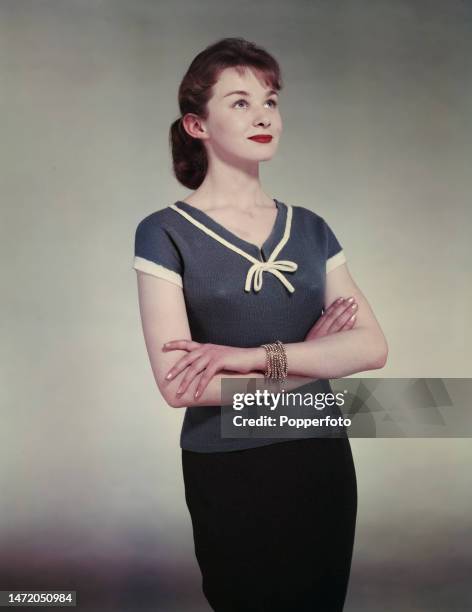 Posed studio portrait of a woman wearing a nautical style short sleeved knit jersey in navy with white trim, London, 21st June 1958.