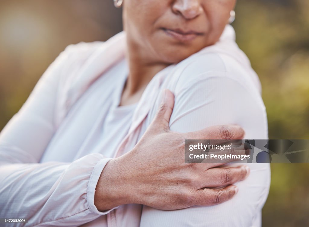 Senior woman, sports injury and shoulder pain at park after accident. Wellness, health and hand of elderly female on arm with muscle inflammation or fibromyalgia after exercise or training outdoors.