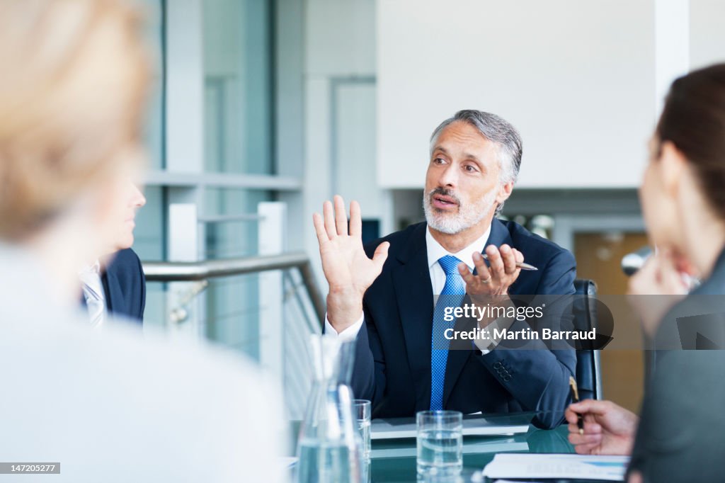 Gesturing businessman leading meeting in conference room