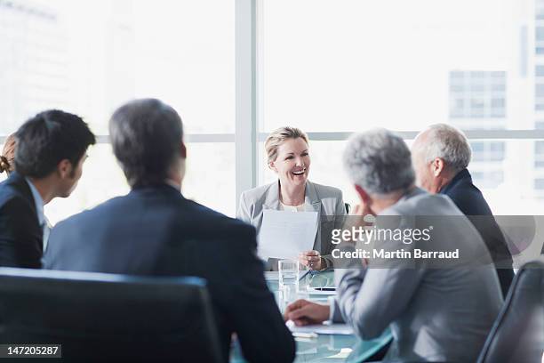 sorridente donna d'affari, leader di una riunione in una sala conferenze - riunione commerciale foto e immagini stock