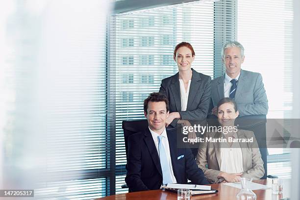 portrait of smiling business people in conference room - four people office stock pictures, royalty-free photos & images