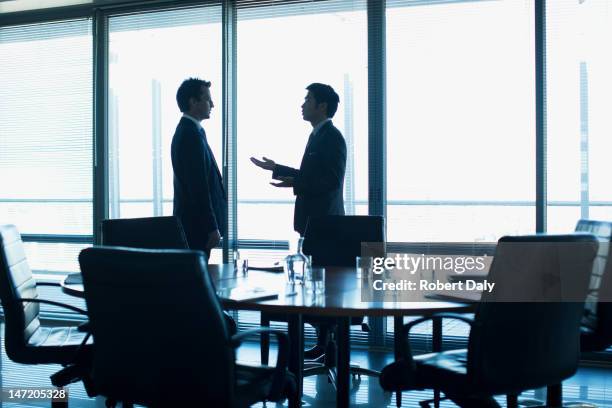 empresário falar cara a cara na sala de conferência - persuasão imagens e fotografias de stock