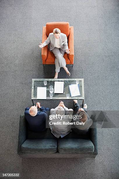 businesswoman leading meeting with co-workers in lobby - influence stockfoto's en -beelden