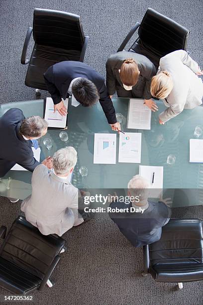 geschäftsleute huddled um papierkram auf tisch - man check suit stock-fotos und bilder