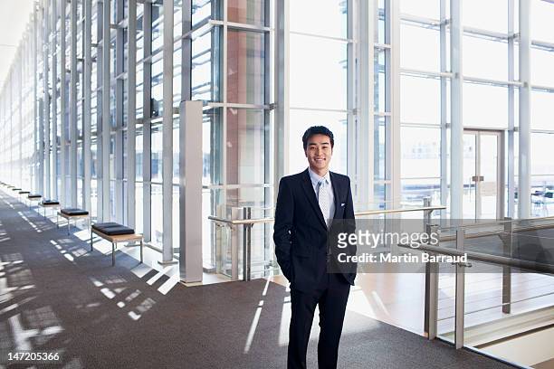 portrait of smiling businessman in modern lobby - person standing front on inside bildbanksfoton och bilder