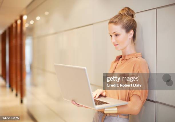 mujer de negocios usando una computadora portátil en la zona - chignon fotografías e imágenes de stock