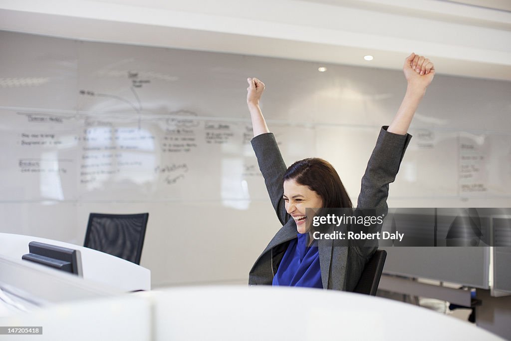 Entusiasmados Mulher de negócios com os braços levantados no escritório