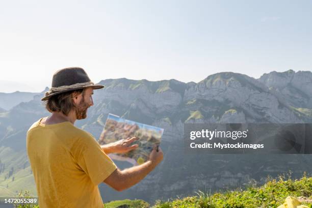 male hiker reads trail map in the swiss alps, people outdoor activities summer concept - appenzell innerrhoden stock pictures, royalty-free photos & images