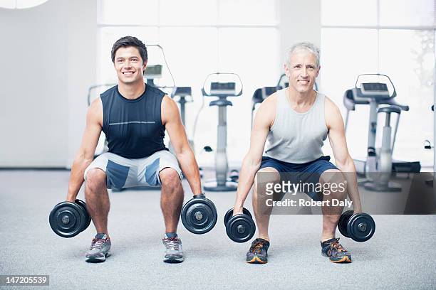 hombre haciendo squats con pesas en el gimnasio - hombre agachado fotografías e imágenes de stock