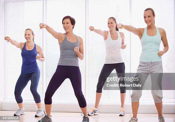 sonriente mujer en clase de ejercicio - defensa propia fotografías e imágenes de stock