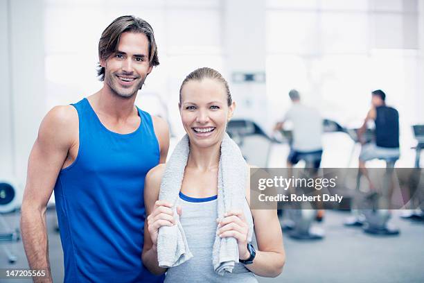 portrait of smiling man and woman in gymnasium - after workout towel happy stock pictures, royalty-free photos & images