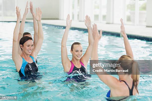 women taking water aerobics class in swimming pool - indoor swimming pool stock pictures, royalty-free photos & images