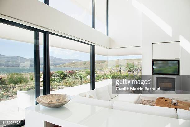 living room overlooking lake - modern windows stock pictures, royalty-free photos & images