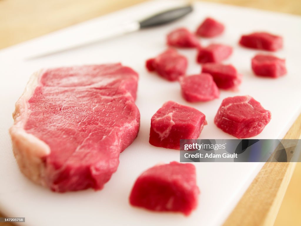 Cubed raw steak on cutting board