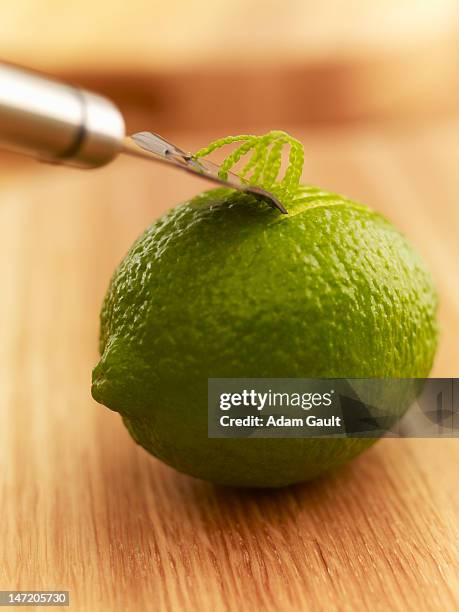 close up of zester peeling lime - zitruszeste stock-fotos und bilder