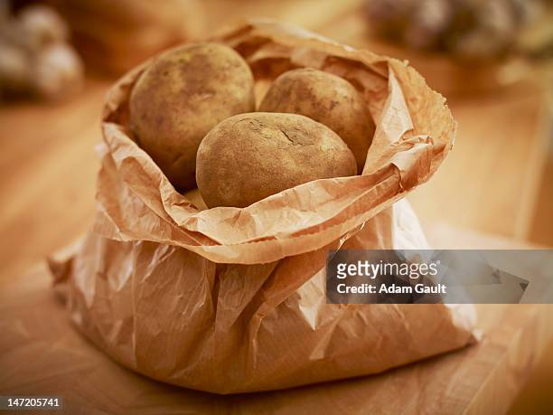 organic potatoes in paper bag - bag of potato chips stockfoto's en -beelden