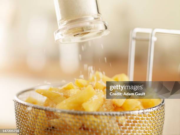 french fries sprinkled with salt - cooking french fries stock pictures, royalty-free photos & images
