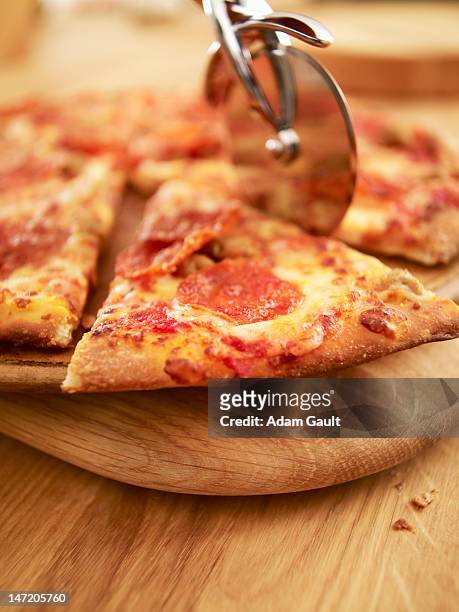 pizza being sliced - ピザカッター ストックフォトと画像