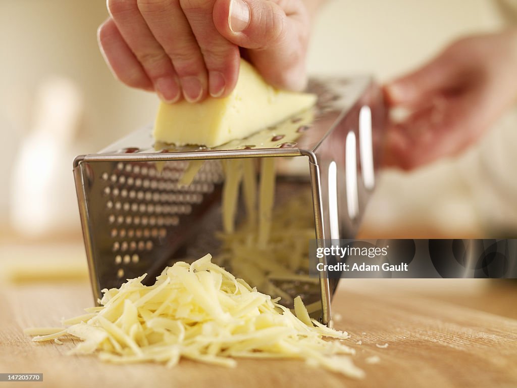 Woman shredded cheese with grater