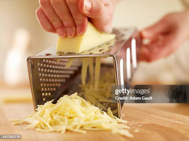 woman shredded cheese with grater - reibe stock-fotos und bilder