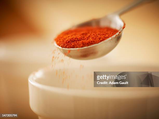 close up of spice in measuring spoon sprinkling into bowl - adding spice stock pictures, royalty-free photos & images