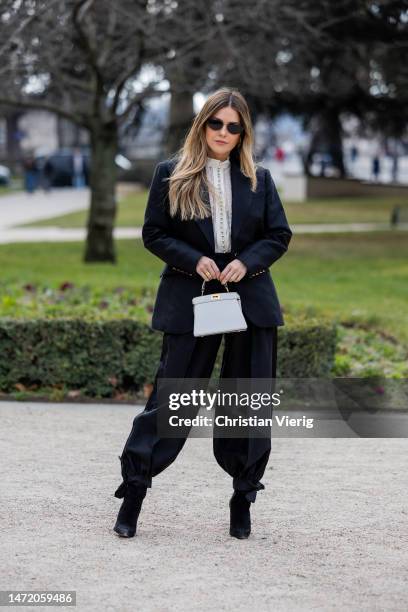 Paola Alberdi wears grey Hermes bag, black blazer, pants, ankle boots, white blouse, sunglasses outside Zimmermann during Paris Fashion Week -...